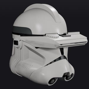 Pode incluir: Um capacete branco e cinza com viseira e design distinto. O capacete tem um topo arredondado com uma se&ccedil;&atilde;o elevada e uma viseira retangular. O capacete tem duas aberturas circulares na parte inferior e um detalhe cinza escuro.