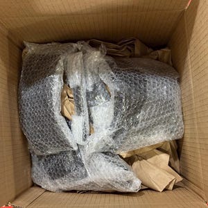 Pode incluir: Uma caixa de cart&atilde;o aberta contendo itens pretos embalados em pl&aacute;stico bolha e papel castanho. Os itens s&atilde;o novos e protegidos para envio.