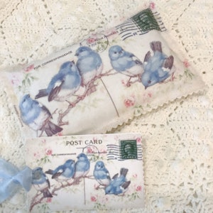 Postal vintage de pájaros azules, bolsita de rosas rosadas, capullos de lavanda francesa o pétalos de rosa
