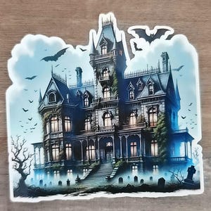May include: A sticker featuring a detailed illustration of a gothic mansion with bats flying in the sky. The mansion is dark blue and gray, with lit windows and a spooky graveyard in the foreground. A perfect Halloween decoration.