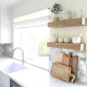 May include: White kitchen with a window, a sink, and two wooden shelves. The shelves are decorated with plants, dishes, and kitchen tools. The text on the containers reads "Salt" and "Pepper".
