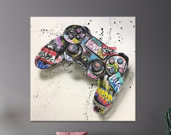 May include: A black and white graffiti-style painting of a video game controller on a white background. The controller is covered in colorful graffiti and has a 3D effect.