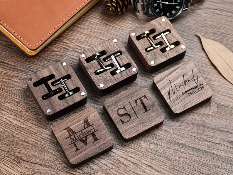 May include: Five wooden boxes with engraved names and dates. Two boxes contain cufflinks, and three boxes have engraved initials. The boxes are made of dark wood with a natural finish.