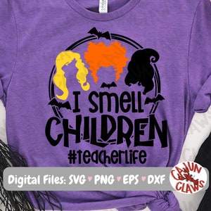 May include: Purple t-shirt with a black and orange graphic of three witches with the text "I smell children #teacherlife".