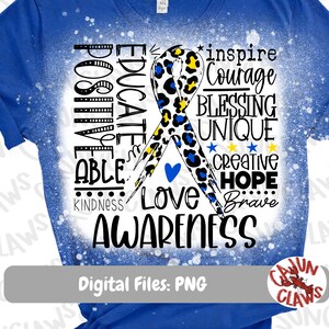 May include: Blue t-shirt with a white bleach design of a blue and yellow ribbon with a leopard print overlay. The ribbon is surrounded by words including "Educate", "Positive", "Able", "Love", "Awareness", "Inspire", "Courage", "Blessing", "Unique", "Creative", "Hope", "Brave", and "Kindness".