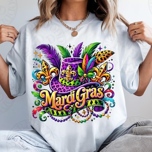 May include: A white t-shirt with a colorful Mardi Gras design featuring a purple, green, and gold hat with leopard print, feathers, and beads.