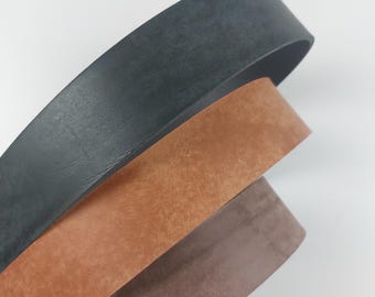 May include: Three leather straps in different colors: black, brown, and gray. The straps are rolled up and stacked on top of each other.