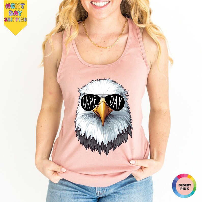 A woman wearing a pink tank top with a graphic of an eagle wearing sunglasses and the text "GAME DAY" printed on it.
