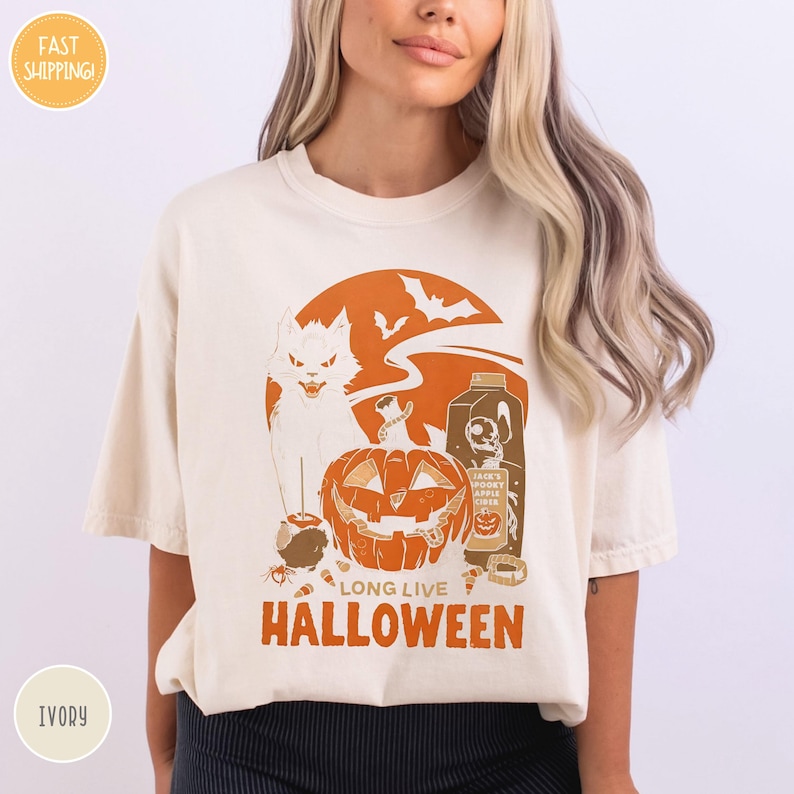 a woman wearing a t - shirt with a cat and pumpkin on it