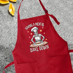 a red apron that says having a mental bake down