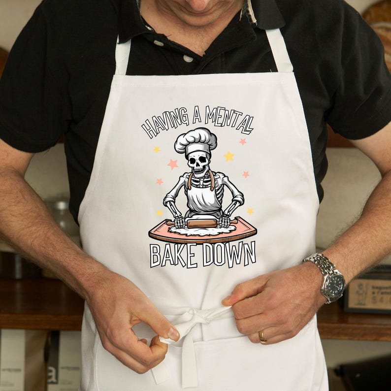 a man wearing an apron holding a doughnut