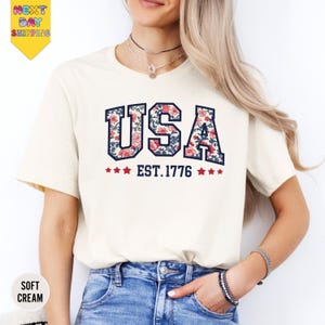 a woman wearing a usa t - shirt and jeans