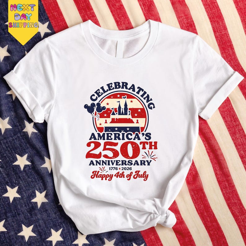 A white t-shirt with a graphic design celebrating the 250th anniversary of America, featuring a red, white, and blue color scheme and an American flag pattern.