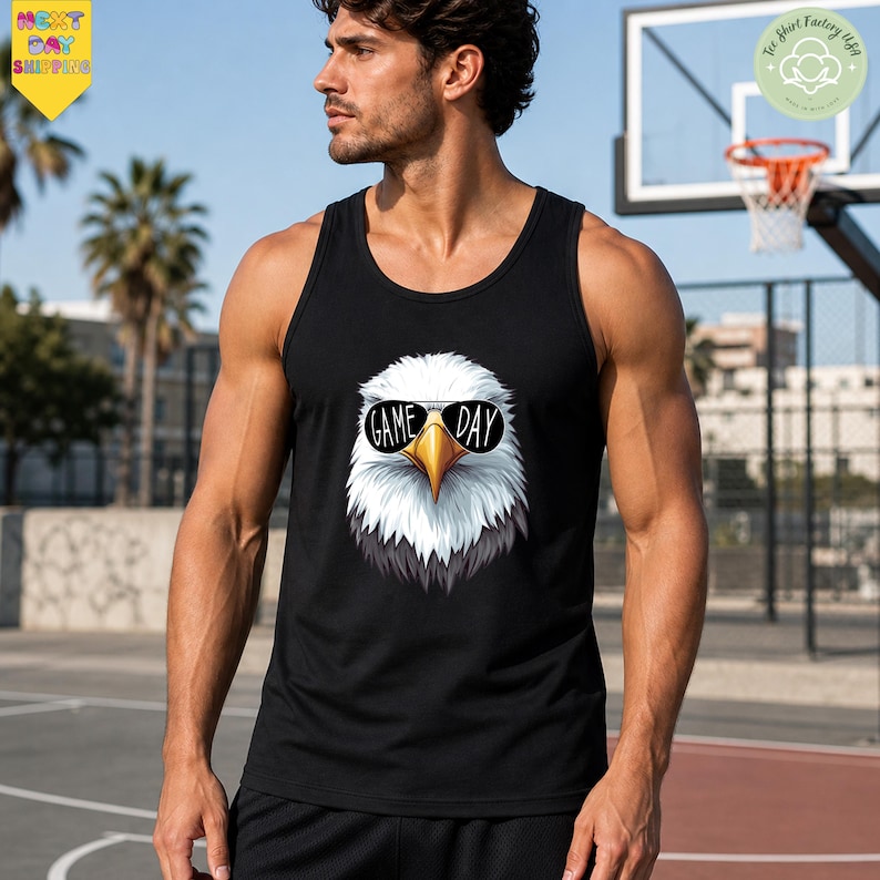 A man wearing a black tank top with a graphic of an eagle and the text "GAME DAY" stands in front of a basketball hoop.