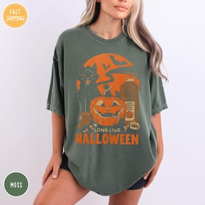 a woman wearing a green t - shirt with an orange pumpkin on it