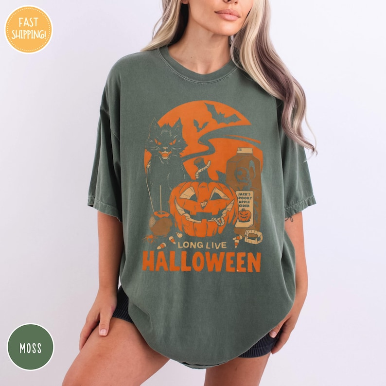 a woman wearing a green t - shirt with an orange pumpkin on it