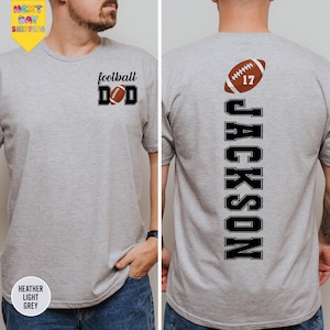 a man wearing a gray shirt with a football on it