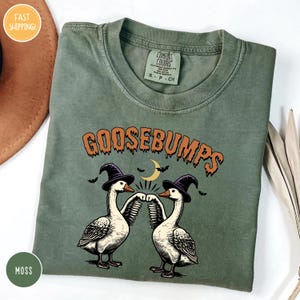 goose bumps t - shirt on a table next to a hat