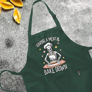 a green apron that says baking a mental bake down