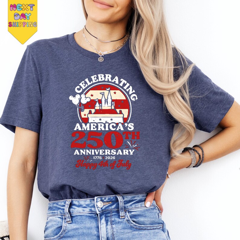 A woman wearing a blue t-shirt with a graphic design celebrating America's 250th anniversary.
