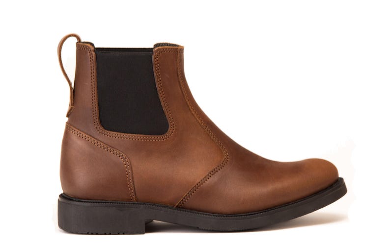 Pode incluir: Uma bota Chelsea de couro castanho com um painel lateral el&aacute;stico preto e uma presilha. A bota tem bico arredondado e sola preta. As costuras s&atilde;o vis&iacute;veis ao longo das costuras. A bota tem cerca de 15 cm de altura.