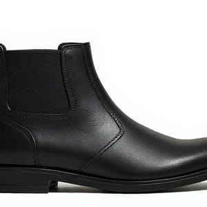 Pode incluir: Bota Chelsea de couro preto com bico arredondado e pain&eacute;is laterais el&aacute;sticos. A bota de tornozelo apresenta uma aba na parte de tr&aacute;s e um salto baixo. A bota &eacute; um estilo cl&aacute;ssico, adequado para v&aacute;rias ocasi&otilde;es.