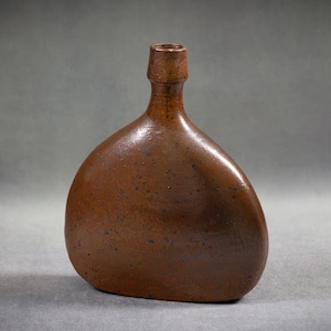 May include: A brown ceramic vase with a rounded, asymmetrical shape and a textured surface.