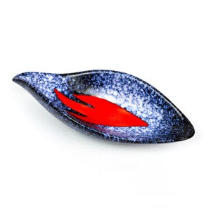 May include: A ceramic leaf-shaped dish with a speckled blue and white exterior and a vibrant red interior design. The dish has a glossy finish. This decorative piece is ideal for serving snacks or as a decorative accent. The dish is set against a white background.