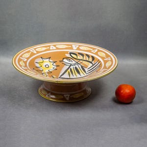Vue d’ensemble avec un fruit en comparaison, montrant l’échelle réelle de la coupe décorative