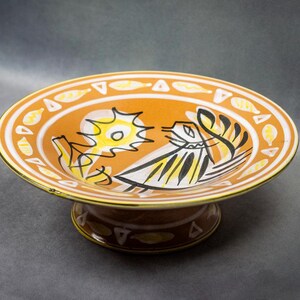 Vue en plongée de trois quarts sur la coupe mettant en évidence les couleurs vives et le motif central