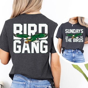a woman wearing a black bird gang t - shirt