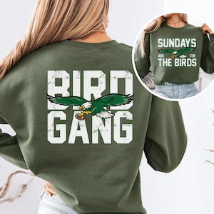 a woman wearing a green bird gang sweatshirt