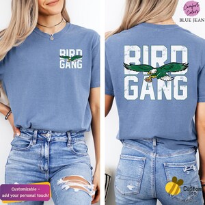a woman wearing a blue bird gang t - shirt