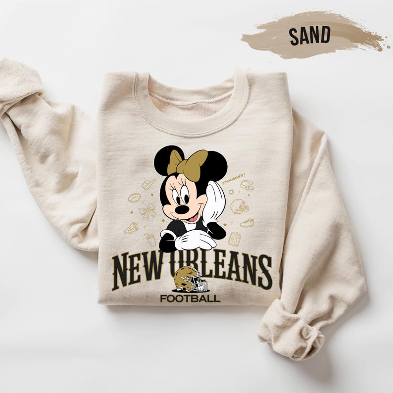 A beige sweatshirt with a cartoon image of Minnie Mouse and the text "New Orleans Football" printed on it.