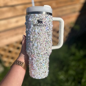 Puede incluir: Una taza de cer&aacute;mica blanca con un asa negra y el texto "But First, Coffee" en negro, con una fuente de estilo manuscrito. La taza est&aacute; sobre una superficie blanca.