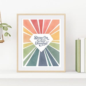 May include: A framed print with a rainbow background and a diamond shape in the center. The diamond shape has the text "Shine On You Crazy Diamond" inside.