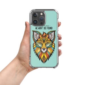 May include: A clear phone case with a teal background and a colorful, intricate fox design. The text "SECRET PLACES - WE WON'T BE FOUND" is printed on the case.