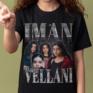 May include: A black short-sleeved t-shirt featuring a graphic print of Iman Vellani. The design includes the name IMAN VELLANI in large metallic silver lettering above and below a collage of four photographic portraits of the actor.