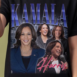 May include: Black t-shirt featuring a graphic of Kamala Harris with the name "KAMALA" in large blue letters at the top. The graphic includes multiple images of Kamala Harris and the name "Harris" in a cursive font.