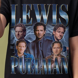 Puede incluir: Camiseta negra con un diseño gráfico con el texto "LEWIS PULLMAN" en una fuente azul desgastada. El diseño incluye múltiples imágenes de un hombre con un fondo de rayos.