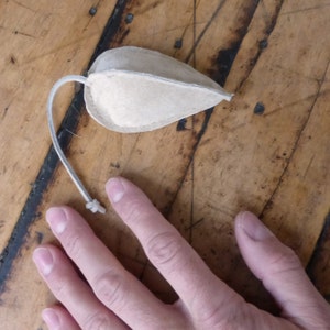 Puede incluir: Un juguete para gato de cuero marr&oacute;n en forma de rat&oacute;n con una cuerda larga.