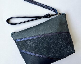 Cleave wristlet pouch, medium. Repurposed blue leather and metallic blue strips, gunmetal zipper, fully lined clutch.