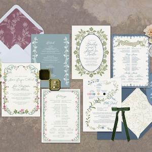 Może przedstawiać: Zestaw papeterii ślubnej, w tym zaproszenia, menu i karty RSVP. Projekty zawierają kwiatowe obramowania w kolorach zielonym, r&oacute;żowym i niebieskim, z eleganckimi czcionkami skryptowymi. Otwarty pojemnik na pierścionek i gałązka białych kwiat&oacute;w są r&oacute;wnież dołączone.