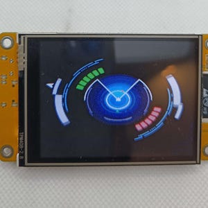 May include: A small, blue and black screen with a circular graphic displaying a blue circle with a white pointer and a green and red bar graph. The screen is mounted on a yellow circuit board with the text "TPMA02-2.8" printed on the side.