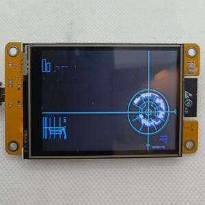 May include: A small, blue and black LCD screen with a circular graphic on the right side of the screen. The screen is mounted on a yellow circuit board with black connectors and the text "T-PIN40B-2.8" printed on the board.