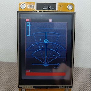 May include: A blue and white radar screen with a red bar at the bottom. The screen is on a yellow circuit board with the text "TPM408-2.8" printed on it.