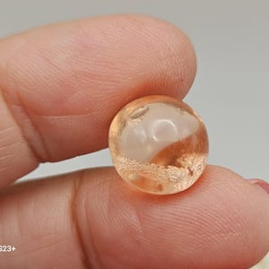 Puede incluir: Una taza de cerámica blanca con un asa negra y el texto "But First, Coffee" en un estilo manuscrito. La taza está sobre una superficie blanca. La taza mide aproximadamente 10 cm de alto.