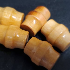 May include: Five wooden knobs in various shades of brown. The knobs are round and have a smooth, polished finish.