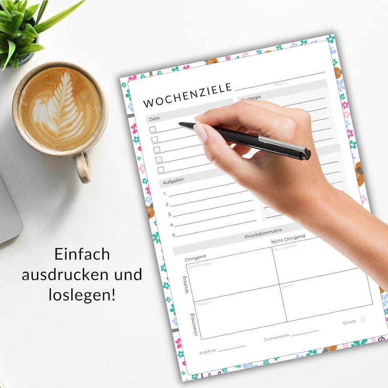 May include: A weekly planner with floral border is being filled out with a pen. The planner has sections for goals, tasks, and a priority matrix. Text on the planner reads "WOCHENZIELE". A cup of coffee sits nearby.