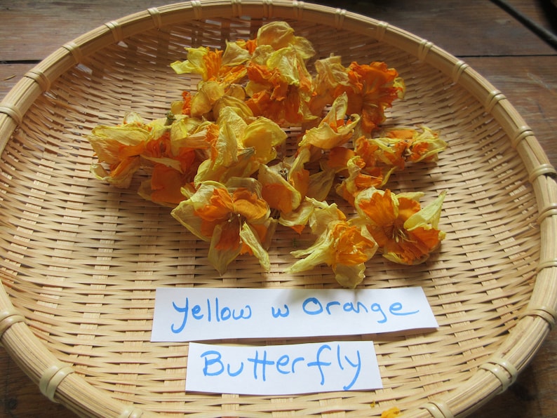 May include: Dried yellow and orange butterfly flowers in a woven basket with a handwritten sign that reads "Yellow w Orange Butterfly"